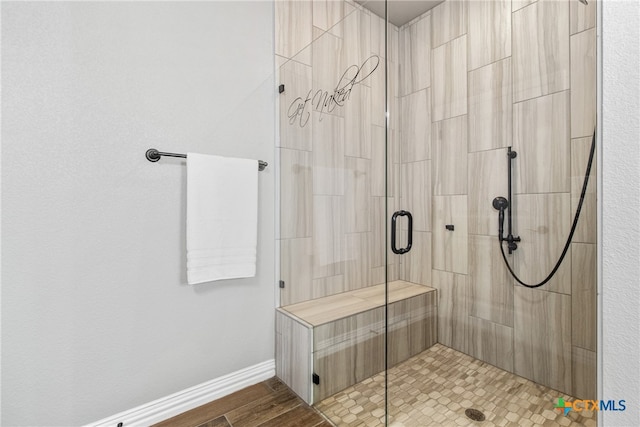 bathroom featuring hardwood / wood-style flooring and a shower with shower door