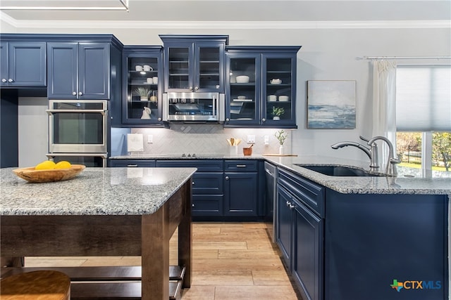 bar with crown molding, sink, light stone countertops, blue cabinetry, and appliances with stainless steel finishes