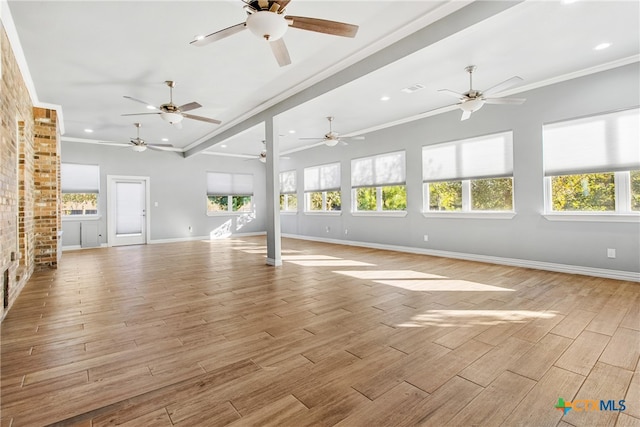 unfurnished living room featuring crown molding, plenty of natural light, and light wood-type flooring