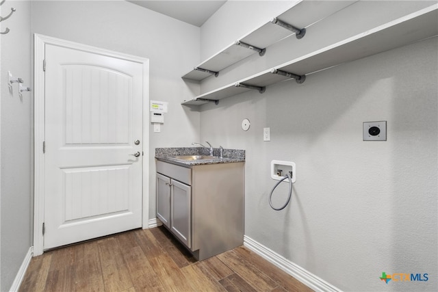 washroom featuring sink, cabinets, hookup for an electric dryer, dark hardwood / wood-style flooring, and hookup for a washing machine