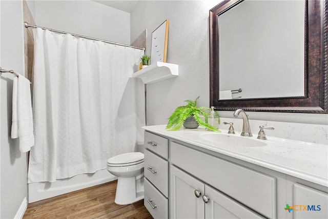 full bathroom with hardwood / wood-style floors, vanity, toilet, and shower / bath combo with shower curtain