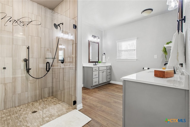 bathroom featuring hardwood / wood-style floors, vanity, and a shower with shower door