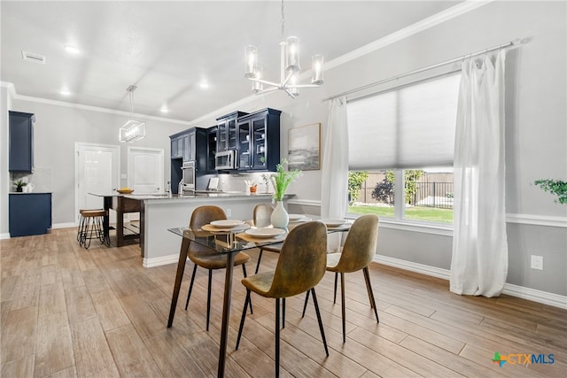 dining room featuring a notable chandelier, light hardwood / wood-style floors, and ornamental molding