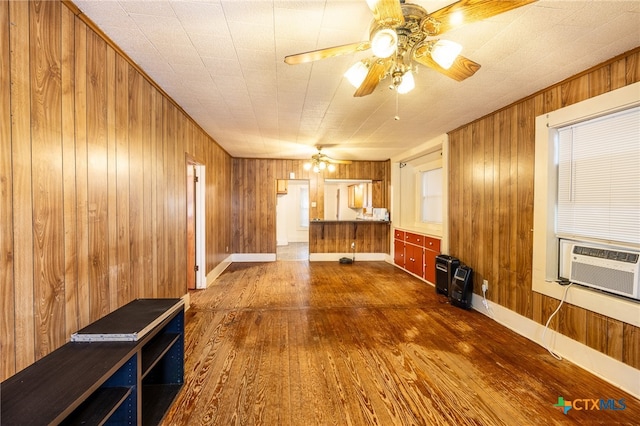 unfurnished living room with dark wood-type flooring and wooden walls