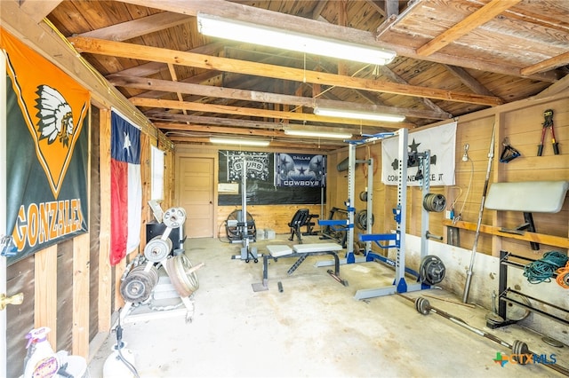 exercise area featuring concrete flooring and vaulted ceiling