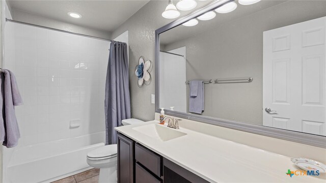 full bathroom with toilet, shower / bath combo, vanity, and tile patterned flooring