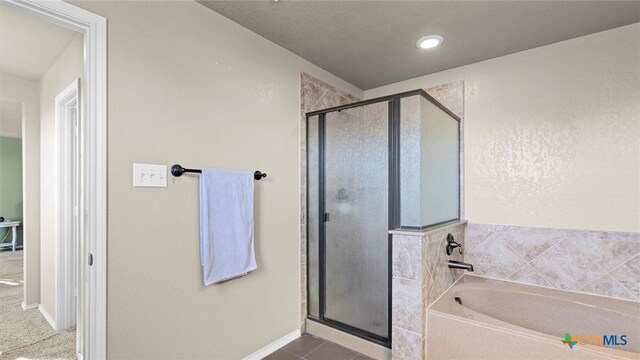 bathroom with tile patterned flooring and separate shower and tub