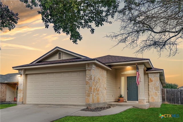 view of front of property with a garage and a yard