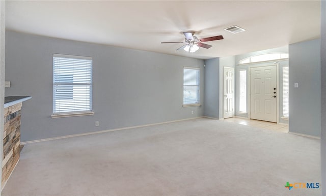 unfurnished living room featuring light carpet and ceiling fan