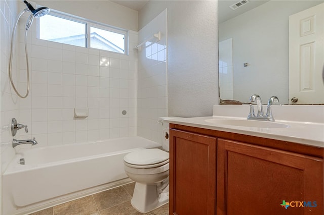 full bathroom featuring toilet, tiled shower / bath combo, vanity, and tile patterned flooring