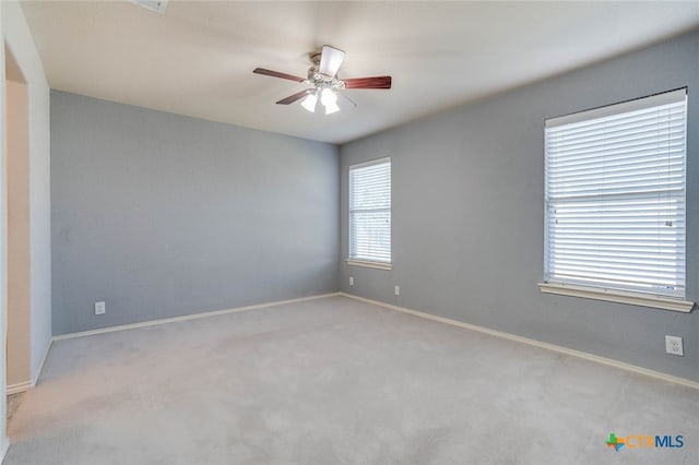 spare room featuring ceiling fan and light carpet