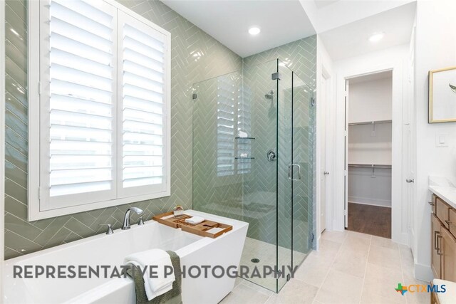 225 Dycus Bnd, Liberty Hill, TX 78642 - bathroom with vanity, a freestanding tub, a stall shower, tile patterned flooring, and recessed lighting