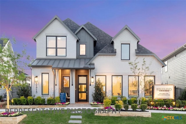 225 Dycus Bnd, Liberty Hill, TX 78642 - view of front of home with a standing seam roof, brick siding, a front lawn, and a shingled roof
