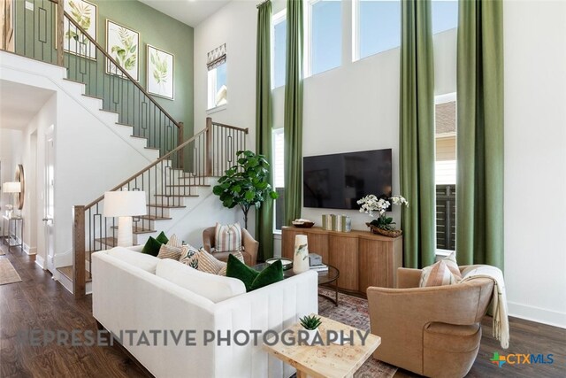 225 Dycus Bnd, Liberty Hill, TX 78642 - living area featuring stairway, a high ceiling, wood finished floors, and baseboards