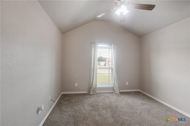 empty room with ceiling fan, lofted ceiling, and carpet floors