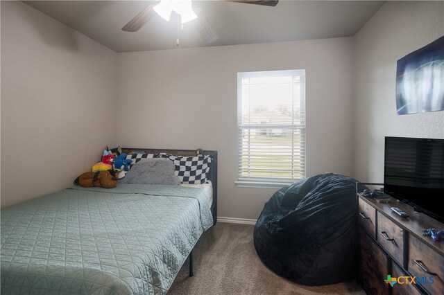 bedroom with a fireplace, ceiling fan, and carpet floors