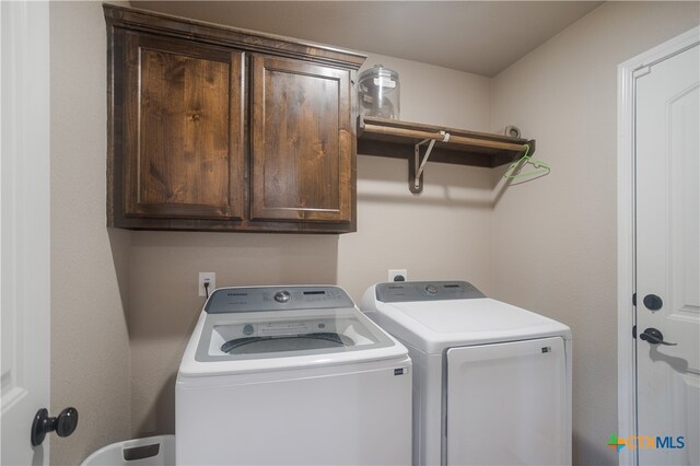 washroom featuring cabinets and independent washer and dryer