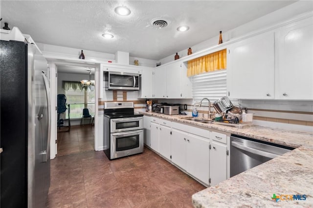 kitchen featuring visible vents, a sink, white cabinetry, and appliances with stainless steel finishes