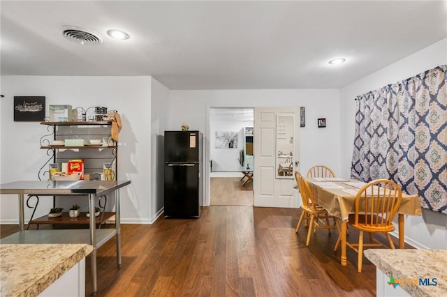 dining space featuring baseboards, visible vents, and dark wood-type flooring