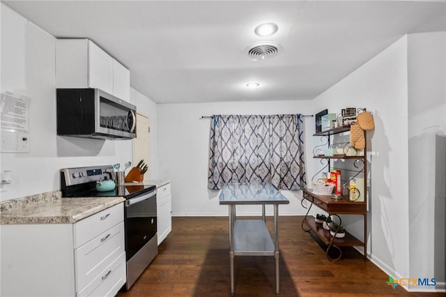 kitchen featuring visible vents, light countertops, white cabinets, stainless steel appliances, and dark wood-type flooring