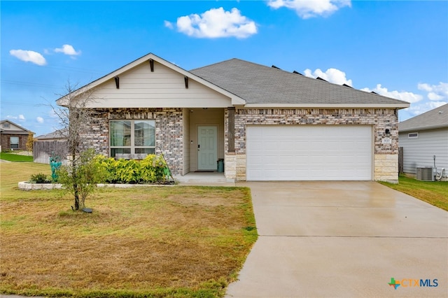 view of front of home with a garage, central AC unit, and a front yard