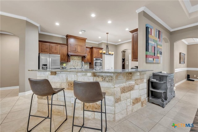 kitchen featuring kitchen peninsula, stainless steel refrigerator with ice dispenser, light stone counters, and a breakfast bar area