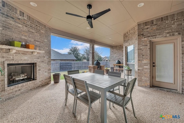 view of patio featuring an outdoor brick fireplace and ceiling fan