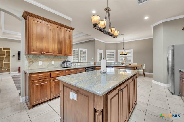 kitchen featuring light stone counters, stainless steel appliances, light tile patterned floors, decorative light fixtures, and a center island