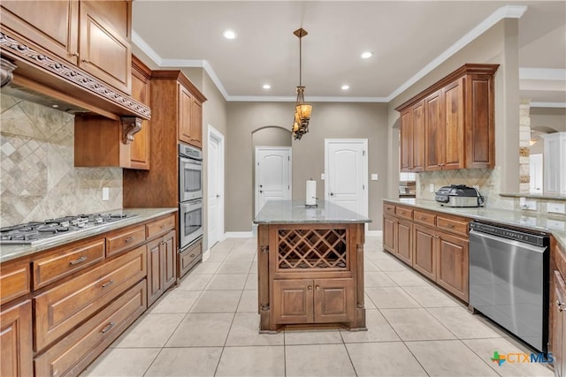 kitchen featuring light stone countertops, appliances with stainless steel finishes, a center island, and crown molding