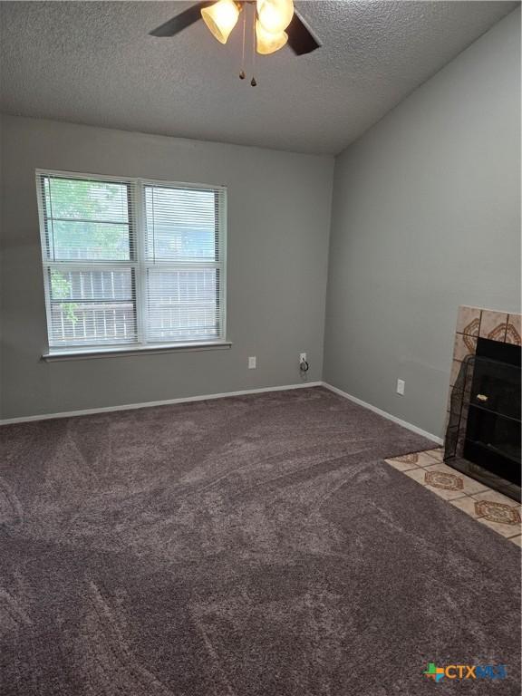 1805 Dickens Dr, Killeen, TX 76543 - unfurnished living room featuring a textured ceiling, a ceiling fan, carpet floors, and baseboards