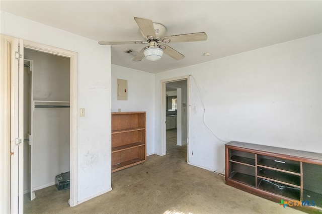 unfurnished bedroom with electric panel, ceiling fan, carpet, and a closet