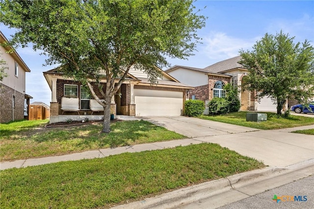 view of property hidden behind natural elements featuring an attached garage, a front yard, driveway, and brick siding