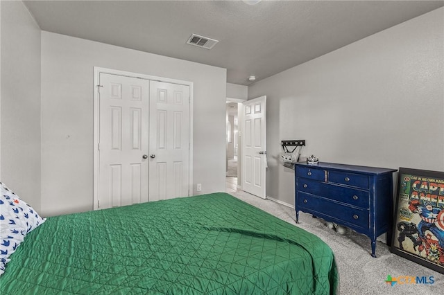 bedroom with visible vents, carpet, and a closet