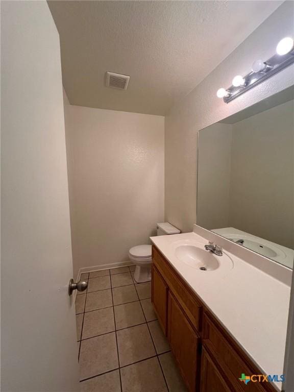 1402 Chips Dr, Killeen, TX 76549 - half bathroom with tile patterned flooring, toilet, vanity, a textured ceiling, and baseboards