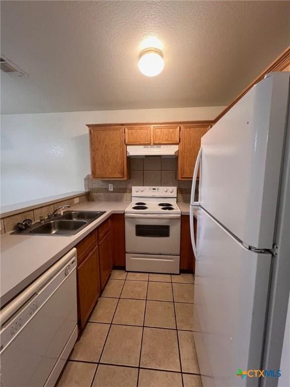 1402 Chips Dr, Killeen, TX 76549 - kitchen featuring white appliances, a sink, under cabinet range hood, light countertops, and light tile patterned flooring