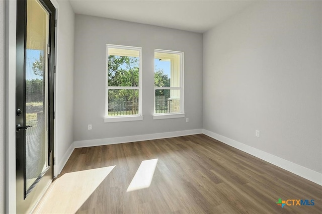 empty room with wood-type flooring and a wealth of natural light