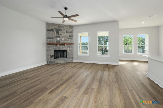 unfurnished living room featuring hardwood / wood-style floors, ceiling fan, and a fireplace