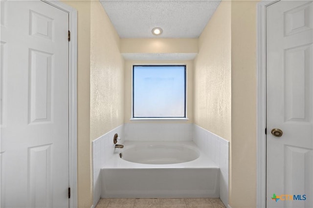 bathroom featuring a tub and a textured ceiling