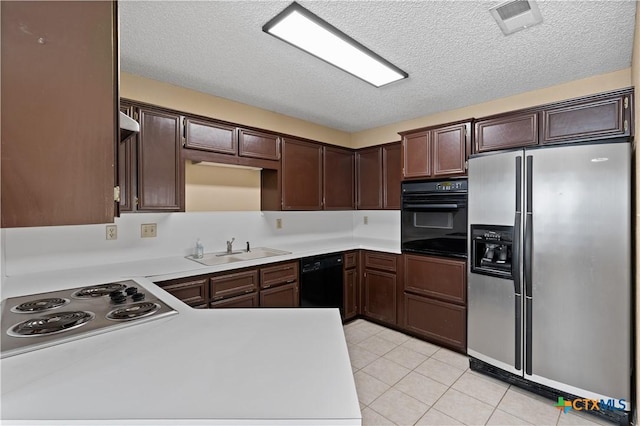 kitchen featuring light tile patterned floors, sink, dark brown cabinetry, and black appliances