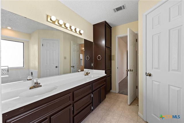 bathroom featuring a textured ceiling, tile patterned flooring, and vanity