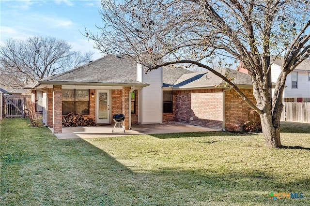 rear view of house featuring a patio area and a yard