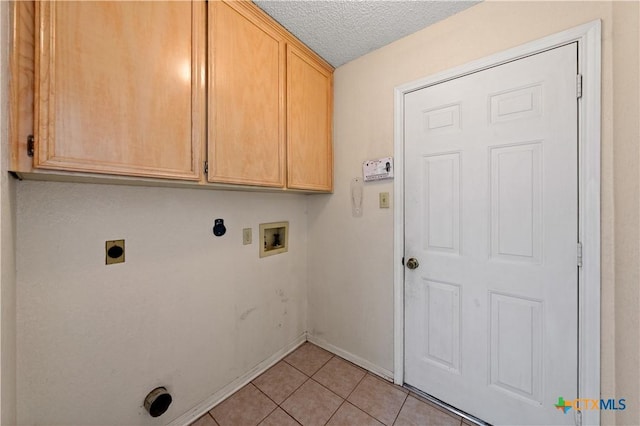 washroom featuring light tile patterned floors, electric dryer hookup, a textured ceiling, washer hookup, and cabinets