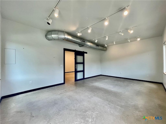 1905 Dutton Dr Unit A, San Marcos, TX 78666 - spare room featuring track lighting, a barn door, concrete flooring, and baseboards