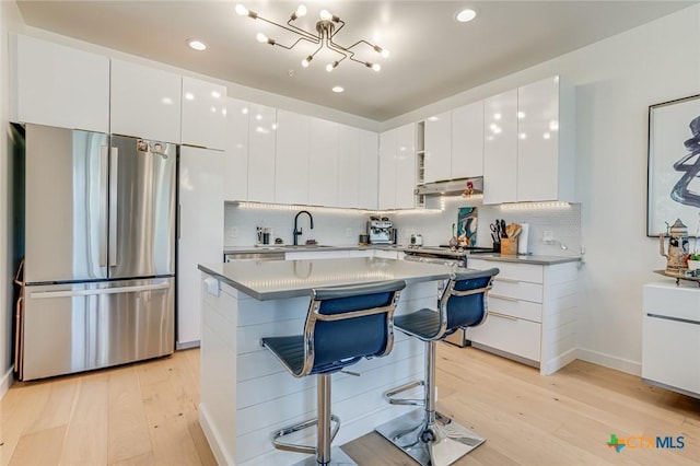 1905 Dutton Dr Unit A, San Marcos, TX 78666 - kitchen featuring freestanding refrigerator, modern cabinets, a sink, light wood-style flooring, and a breakfast bar