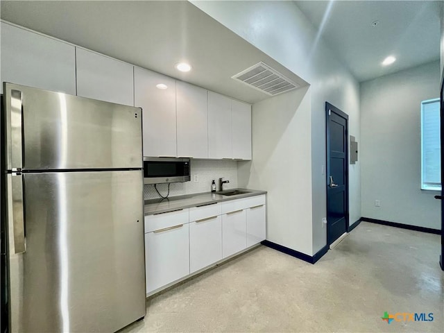 1905 Dutton Dr Unit A, San Marcos, TX 78666 - kitchen with appliances with stainless steel finishes, finished concrete flooring, tasteful backsplash, a sink, and baseboards