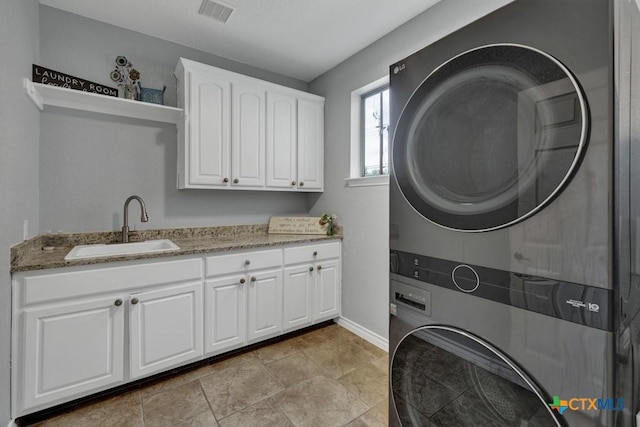 172 River Chase Dr, New Braunfels, TX 78132 - laundry room featuring stacked washing machine and dryer, cabinet space, and baseboards