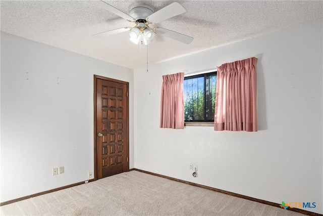 carpeted spare room featuring ceiling fan and a textured ceiling