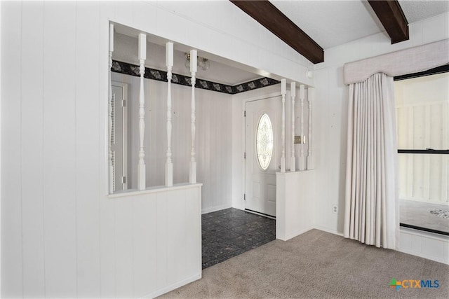 foyer entrance featuring carpet and beam ceiling