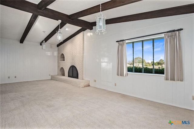 unfurnished living room with a brick fireplace, carpet flooring, and vaulted ceiling with beams