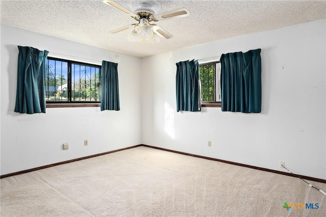 spare room featuring ceiling fan, a textured ceiling, and light carpet